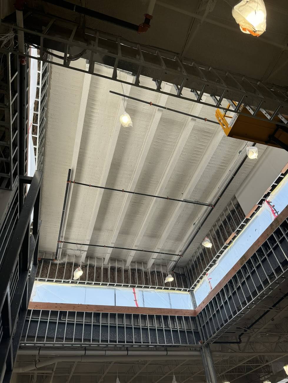 Bahl Fireproofing crew applying fire-resistive material to structural steel