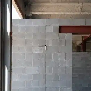 Core-Fill 500: unfinished concrete masonry wall with a small foam injection hole drilled in a mortar joint