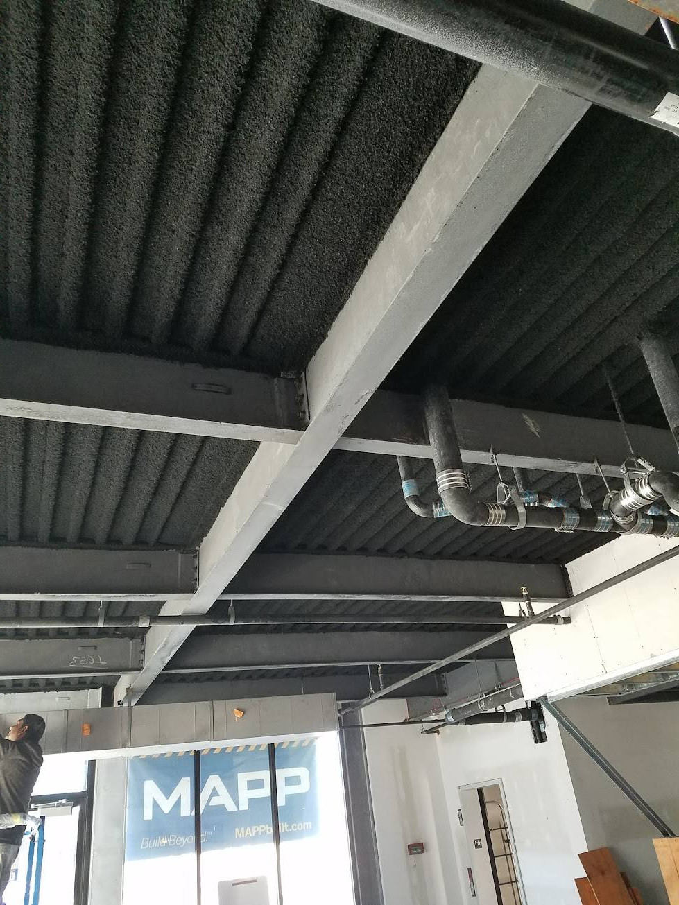 Black k-13 sprayed fiber insulation on a metal roof deck, left exposed as the finished ceiling